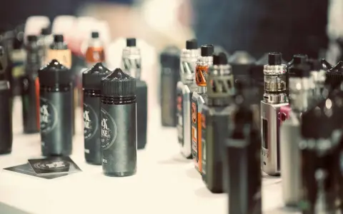 Botellas de líquidos para vapear, con diversos potenciadores de sabor, y dispositivos electrónicos en exhibición.