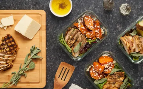 Repas préparés pour manger healthy : poulet grillé, patates douces, fromage et salade.