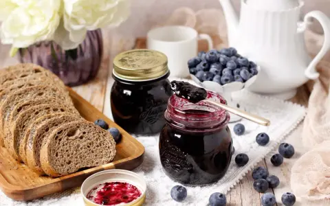 Un petit-déjeuner gourmand avec du pain de campagne, des myrtilles fraîches et une délicieuse confiture de myrtilles.