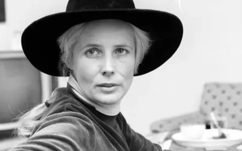 Agnieszka Osiecka w kapeluszu, zamyślona, jakby tworzyła kolejne teksty.