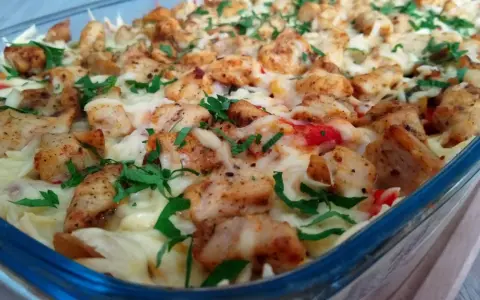 Pyszna zapiekanka gyros z makaronem, posypana serem i natką pietruszki, w szklanym naczyniu.