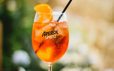 Ett glas med en orange aperol drink utan prosecco, is och en apelsinskiva.