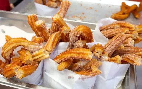 Deliciosos churros recién hechos, cubiertos de azúcar. Una guía visual de como hacer churros perfectos.