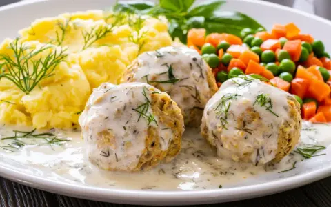 Pyszne pulpety z indyka w sosie koperkowym, podane z puree ziemniaczanym i warzywami.