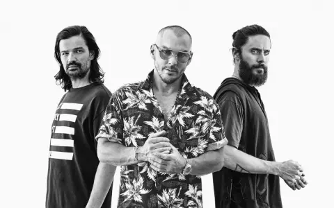 Les membres de Thirty Seconds to Mars posent ensemble, un regard intense sur le visage de Jared Leto.