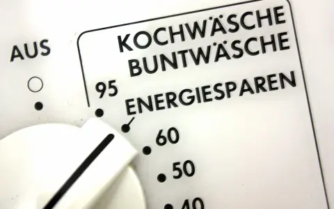 Regler einer Waschmaschine zeigt Programme wie Kochwäsche, Buntwäsche und Energiesparen. Der Wasserverbrauch hängt vom gewählten Programm ab.