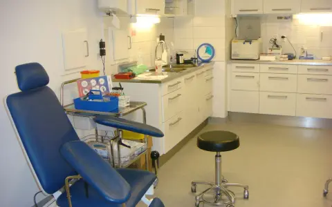 Blå undersökningsstol och medicinsk utrustning i ett kliniskt rum. Förberedelser för att testa för tyfoidfeber.