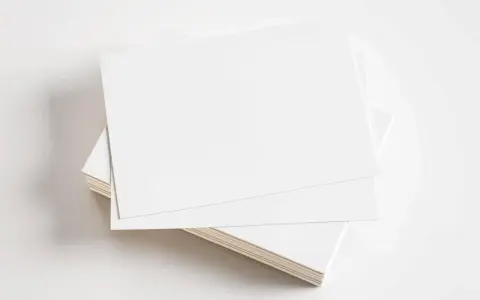 Stos białych kartek, gotowych do zadrukowania. Idealne na wizytówki, zaproszenia lub inne materiały promocyjne z kartonu GC1.