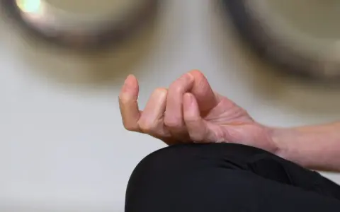 En hand i meditationsställning, fingrarna böjda i en gest som påminner om sa ta na ma. Lugn och ro.