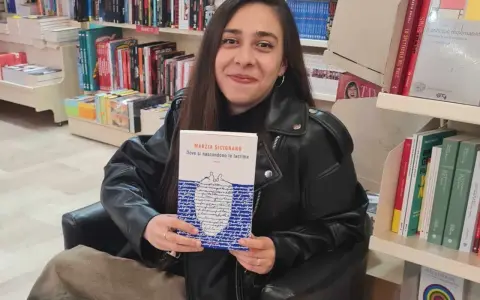 Una giovane donna sorride in libreria, tenendo in mano il libro "Dove si nascondono le lacrime".