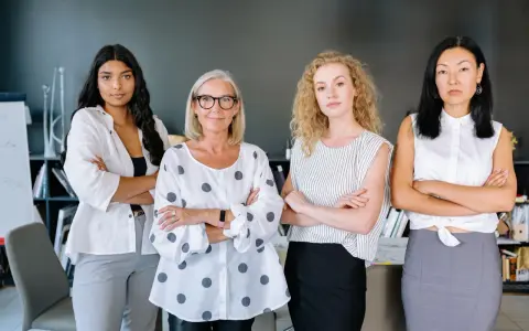 Cuatro mujeres emprendedoras, diversas en edad y etnia, posan con confianza en una oficina.