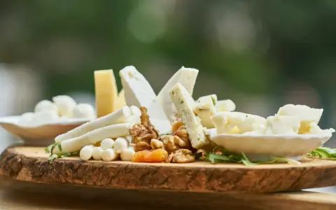 Deska serów z orzechami i suszonymi morelami. Zastanawiasz się, ile kcal ma plaster sera?
