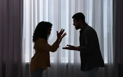 Siluetas de una pareja discutiendo apasionadamente. Ella gesticula con las manos, él la mira fijamente. ¿Será que porque atraigo a personas con problemas?