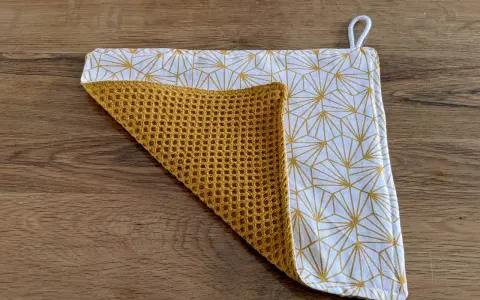 Tuto essuie-tout lavable sans pression : un tissu blanc à motifs géométriques dorés et un tissu éponge moutarde.