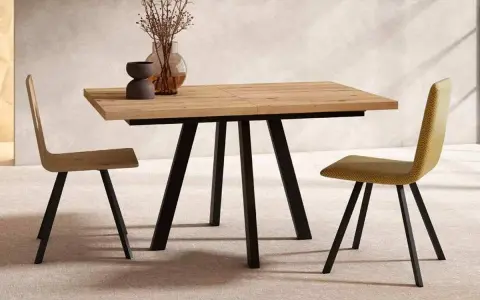 Mesa comedor extensible de madera con patas metálicas negras, ideal para ampliar el espacio. Dos sillas modernas flanquean la mesa.
