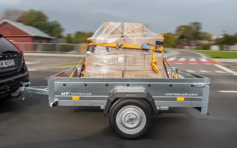 Ładunek na przyczepce jest zabezpieczony pasami. Zastanawiasz się, ile może wystawać ładunek z przyczepki? Przepisy określają dopuszczalne wymiary.