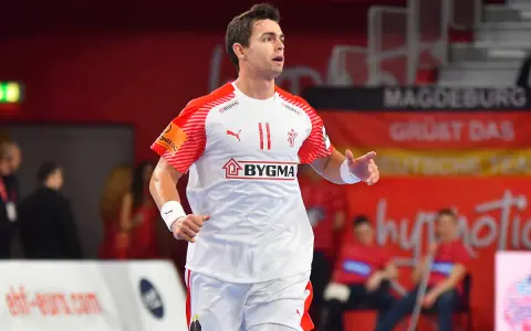 Piłkarz ręczny Rasmus Lauge Schmidt w białej koszulce z czerwonymi rękawami i numerem 11.