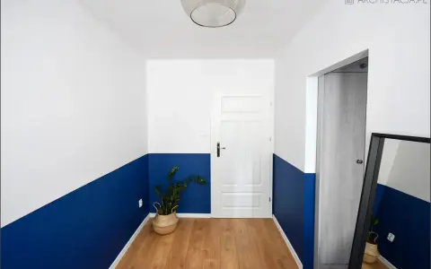 Nowoczesny korytarz z dwukolorową lamperią. Zobacz, jak pomalować lamperie w ciekawy sposób, tworząc geometryczne wzory.