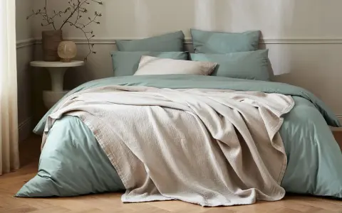 Lit douillet avec housse de couette vert sauge et jeté texturé beige. Quel tissu pour housse de couette ? Le coton doux est idéal.