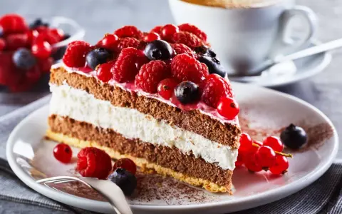 Pyszny tort z malinami i borówkami, idealny na deser. Sprawdzone przepisy na torty znajdziesz w naszej kuchni!