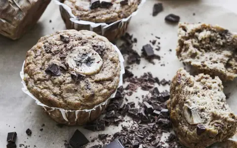 Saftiga bananmuffins med chokladbitar och en bananskiva på toppen. Perfekt för ett banan muffins recept.