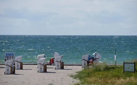 Strandkörbe am Bojendorfer Strand laden zum Entspannen ein. Das Meer glitzert, die Wolken ziehen vorbei.