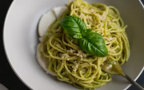 Spaghetti z pesto i mozzarellą, ozdobione bazylią. Czy taki makaron jest dietetyczny? Zależy od składników!