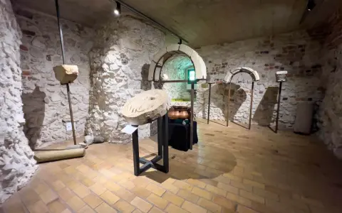 Wnętrze klasztoru w Tyńcu. Kamienne ściany, łuki i artefakty tworzą atmosferę historii.