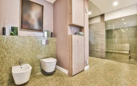 Salle de bain moderne avec bidet et WC suspendu. L'inconvénient du WC suspendu est l'accès au réservoir, caché derrière le mur.