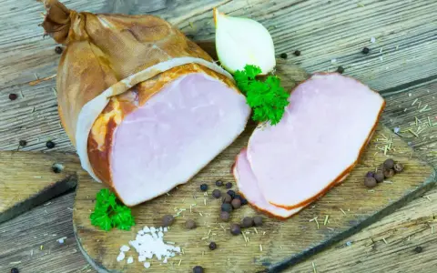 Wędzony kindziuk, czyli wieprzowa szynka, pokrojona na plastry, z cebulą i natką pietruszki.