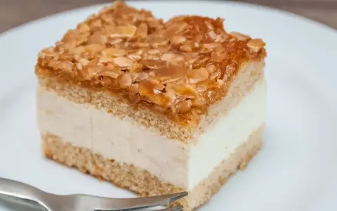 Ein Stück Bienenstich-Kuchen mit cremiger Füllung und karamellisierten Mandeln. Ein leckeres Rezept für den süßen Genuss.