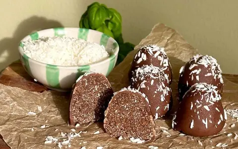 Chokladbollar recept: Mörka, kokosdränkta godsaker med en skål riven kokos i bakgrunden. Perfekt för fikat!