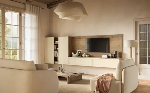 Soggiorno accogliente con divani color visone abbinamento, mobile TV in legno e pareti color crema. Luce naturale entra da un'ampia finestra.