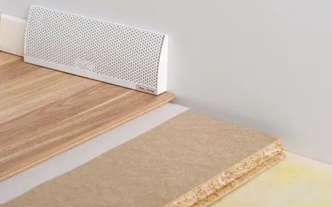 En vit ventilationslist för ett passivt ventilerat golv, med trägolv och byggmaterial.