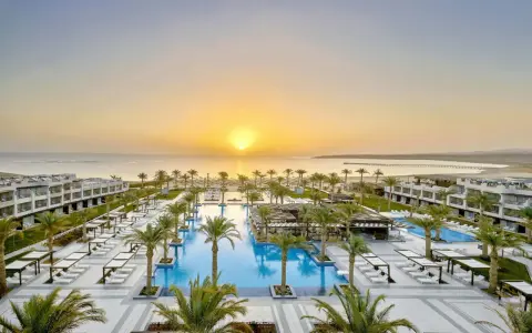 Zachód słońca nad basenem i palmami w Iberotel Costa Mares. Luksusowy kurort zaprasza na relaks.