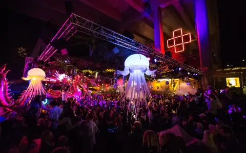 En livlig nattklubb i Stockholm med uppblåsbara maneter, discokulor och en stor publik som dansar under neonljus.