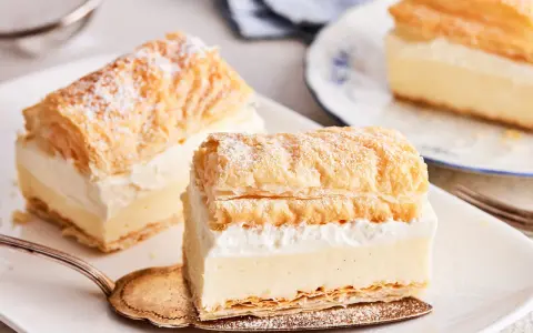 Zarte Cremeschnitten, die nach dem original cremeschnitten rezept zubereitet wurden, bestäubt mit Puderzucker.