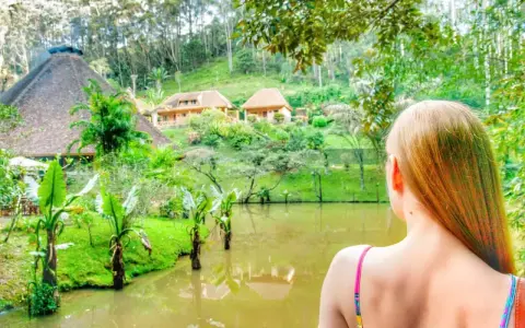 Widok na malowniczy krajobraz z jeziorem i domkami w stylu madagaskarskim. Atrakcje przyrodnicze i architektoniczne zachwycają.