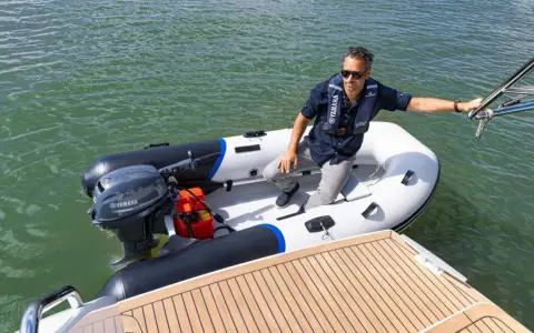 Un homme en gilet de sauvetage dans un semi-rigide, prêt à partir avec le moteur bateau 6cv le plus puissant.