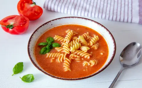 Zupa pomidorowa z makaronem fusilli, świeżą bazylią i pomidorami. Idealne jakie przyprawy do zupy pomidorowej? Bazylia i czosnek!