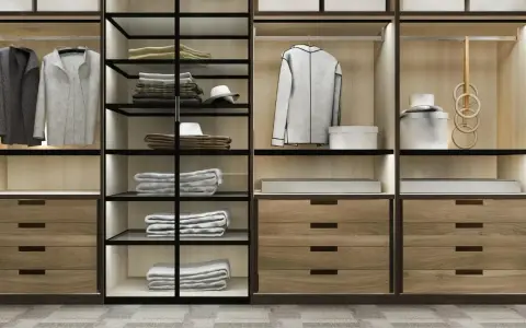 Un moderno armario empotrado con puertas de cristal y madera, organizado con ropa doblada, colgada y accesorios.