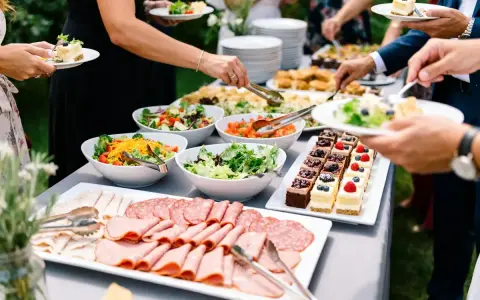 Un délicieux buffet froid avec salades fraîches, charcuteries variées et petits gâteaux colorés, prêt à régaler les convives.