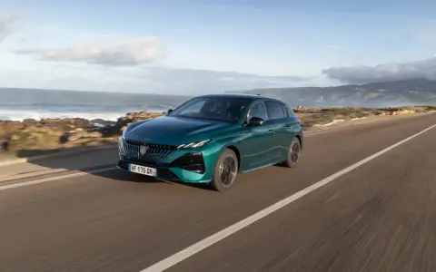 Zielony Peugeot 308 jedzie wzdłuż malowniczego wybrzeża.