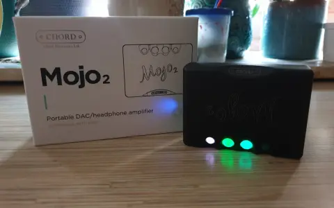 Zestaw Chord Mojo 2: pudełko i czarny wzmacniacz z podświetlanymi przyciskami.