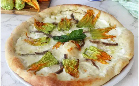 Pizza con fiori di zucca, mozzarella filante e acciughe. Un sapore delicato e profumato, perfetto per l'estate.