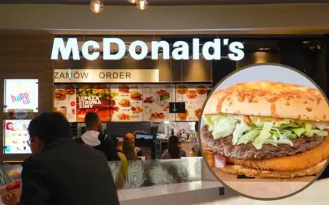 Zbliżenie na burgera McDonald's na tle wnętrza restauracji z menu.