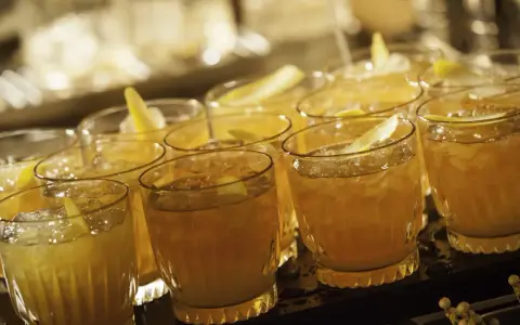 Mehrere Cognac Cocktails mit Eis und Zitronenzeste, bereit zum Servieren.