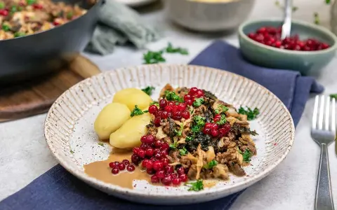 En tallrik med köttfärs och kål, serverad med kokt potatis och lingon. Ett härligt kålmaja recept som ser utsökt ut!