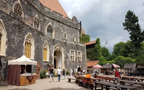 Kamienny zamek Grodziec z gotyckimi oknami, dziedziniec z kramami i ławami. Wiele osób zwiedza to miejsce, a opinie o zamku Grodziec są pozytywne.