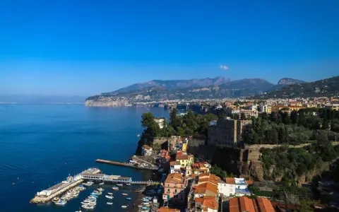 Vista panoramica di Sorrento: cosa vedere a Sorrento in un giorno, con il porto, le case colorate a picco sul mare e i monti sullo sfondo.